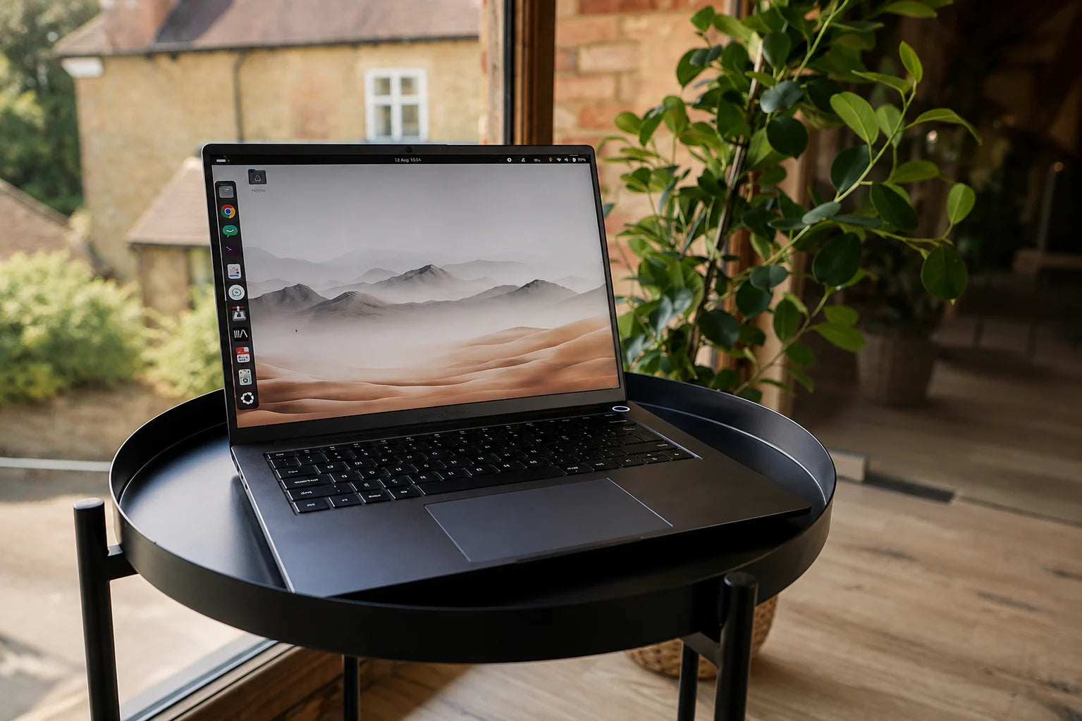 The StarBook Horizon running Linux on a table beside a window